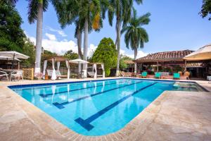 a swimming pool with palm trees in the background at Entre Palmas Casa Hotel in Santa Fe de Antioquia
