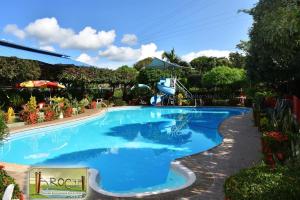 a large blue swimming pool with a slide in it at Hotel El Broche in Yopal