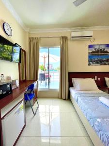 a hotel room with a bed and a television at Hulhan'gu Lodge in Himmafushi