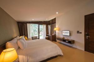 Un dormitorio con una gran cama blanca y una ventana en FLAMINGO DAI LAI RESORT - luxury, en Ngọc Quang