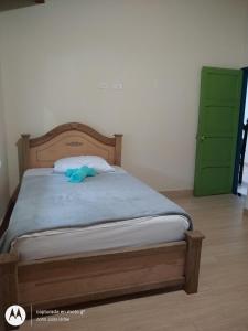 a bed in a room with a green cabinet at Hostal Naty Luna in Jardin