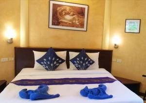 two blue teddy bears sitting on top of a bed at Palm Garden Resort in Khao Lak