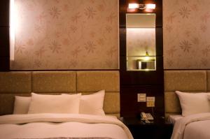 a hotel room with a bed and a mirror at Wogo Hotel in Yilan City