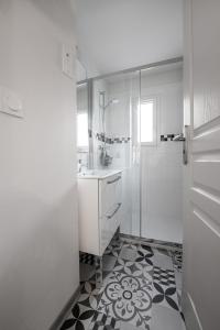 a white bathroom with a sink and a shower at Lumineux appartement, 3min de la gare, équipé fibre,bonsejour19 in Tulle