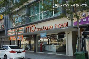 馬六甲的住宿－MIO BOUTIQUE Hotel，停在大楼前的白色汽车