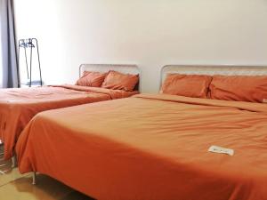 2 nebeneinander sitzende Betten in einem Schlafzimmer in der Unterkunft Holiday Homestay Seremban in Seremban