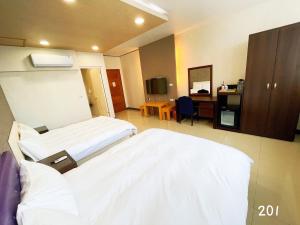 Habitación hospitalaria con 2 camas y escritorio en 花蓮花見你民宿 en Hualien