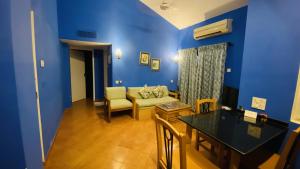 a blue living room with a couch and a table at Lotus Eco Beach Resort - Goa in Benaulim