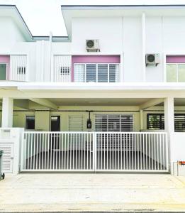une maison blanche avec une clôture blanche dans l'établissement Holiday Homestay Seremban, à Seremban