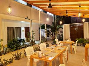 a restaurant with wooden tables and white chairs at Dhonkamana Stay in Thoddoo