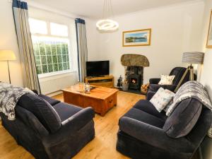 a living room with two couches and a fireplace at Ty'r Ysgol in Morfa Bychan