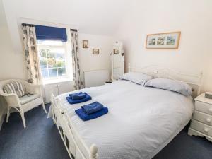 a bedroom with a large white bed with blue towels on it at Ty'r Ysgol in Tremadoc