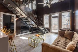 a living room with a couch and a staircase at Louis Vuitton Loft in Atlanta
