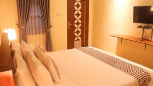 una habitación de hotel con una cama con TV. en Anang Bed & Breakfast Syariah by Ndalem Beong, en Magelang
