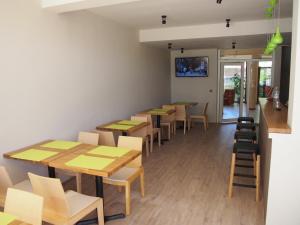 a row of tables and chairs in a restaurant at Hotel Milan in Primorsko