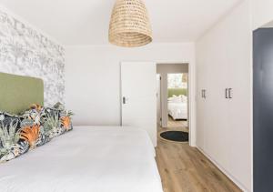 a white bedroom with a large white bed and a room at Plett Holiday Stay with Hut Tub ,Pizza Oven and Views in Plettenberg Bay