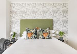 a bedroom with a large white bed with pillows at Plett Holiday Stay with Hut Tub ,Pizza Oven and Views in Plettenberg Bay