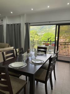 a dining room with a table and chairs and a balcony at B Holiday Apartments in Beau Vallon