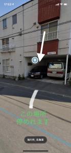 un edificio con un'auto parcheggiata in un parcheggio di 旭山動物園、美瑛、車で30分、旭川中心部徒歩3分 a Asahikawa