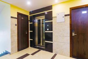 un pasillo con 2 ascensores y una puerta de madera en FabHotel Surya Grand I, en Vijayawāda