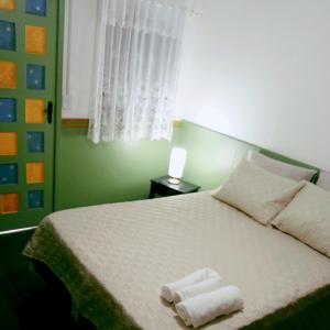 a bedroom with a bed with two towels on it at Pousada Videira de Teresópolis in Teresópolis