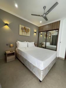 a bedroom with a large white bed with a ceiling fan at B Holiday Apartments in Beau Vallon