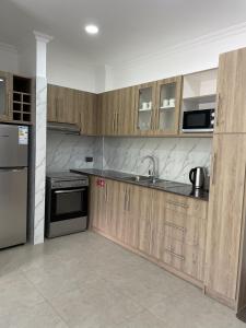 eine Küche mit Holzschränken und Küchengeräten aus Edelstahl in der Unterkunft B Holiday Apartments in Beau Vallon