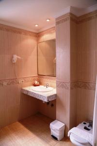 a bathroom with a sink and a toilet and a mirror at Hotel Tio Felipe in Carboneras