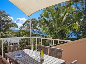 ヌーサヘッズにあるCosta Del Sol 4 Park Road 22のバルコニーにテーブルとワイン1本