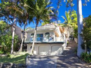 ヌーサヘッズにあるCosta Del Sol 4 Park Road 22の前にヤシの木がある家 +4枚の写真