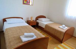 two beds in a small room with towels on them at Apartment by the sea and with beautiful view, 2 bedrooms, 4 persons in Kali