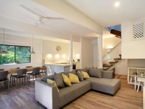 a living room with a couch and a dining room at Little Cove Townhouse 2 Pandanus Street 14 in Noosa Heads