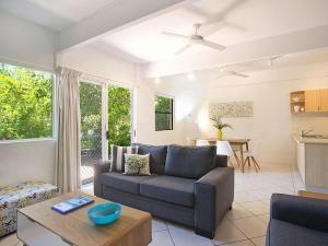 ein Wohnzimmer mit einem Sofa und einem Tisch in der Unterkunft Little Cove Townhouse 5 Pandanus Street 14 in Noosa Heads
