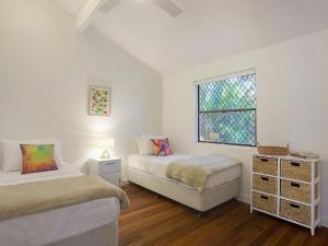 Dieses weiße Zimmer verfügt über 2 Betten und ein Fenster. in der Unterkunft Little Cove Townhouse 5 Pandanus Street 14 in Noosa Heads