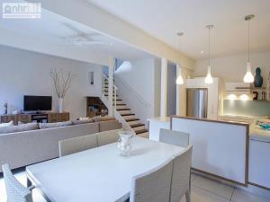 a dining room and living room with a white table and chairs at Little Cove Townhouse 9 Pandanus Street 14 in Noosa Heads