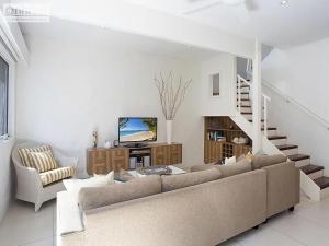 a living room with a couch and a staircase at Little Cove Townhouse 9 Pandanus Street 14 in Noosa Heads