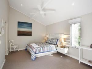 biała sypialnia z łóżkiem i oknem w obiekcie Little Cove Townhouse 9 Pandanus Street 14 w mieście Noosa Heads