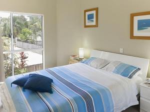 a bedroom with a bed with blue pillows and a window at Noosa River Gardens 8 Hilton Terrace 76 in Noosaville