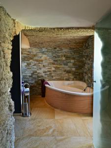 a bath tub in a bathroom with a brick wall at B&B Torre Porta Marina in Ventimiglia +37 photos