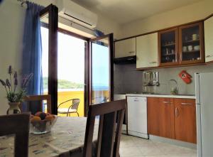 カリにあるApartment for 4 persons, by the sea and with beautiful viewのテーブル付きのキッチン、窓付きのキッチンが備わります。