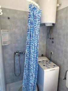a bathroom with a blue shower curtain next to a toilet at Apartment for 4 persons, by the sea and with beautiful view in Kali