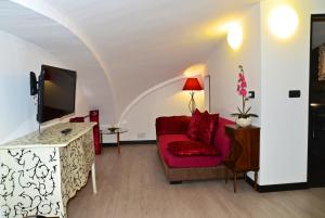 a living room with a red couch and a tv at B&B Torre Porta Marina in Ventimiglia