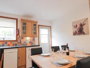 a kitchen with a wooden table with wine glasses at 2 Riverside in Inverness