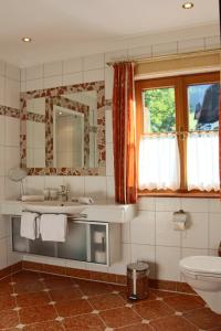 un bagno con lavandino, water e specchio di Ferienwohnung Schossleitner - der Wohlfühl-Ansitz am Wolfgangsee mit Weitblick a Sankt Gilgen Altre 36 foto