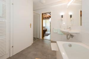 ein weißes Badezimmer mit einer Badewanne und einem Waschbecken in der Unterkunft City Life 2 by Alpenidyll Apartments in Schladming