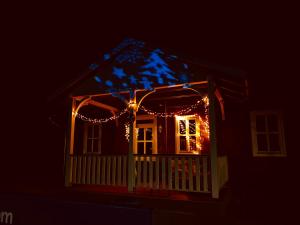 Una casa con luces de Navidad encendidas por la noche en Club Thermal Village Cegled en Cegléd