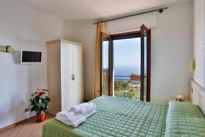 a bedroom with a green bed with towels on it at BB Santalucia in Agerola