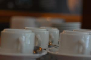 un grupo de tazas y platillos blancos sobre una mesa en The Maple Suite, en Kuala Lumpur