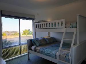 a bedroom with two bunk beds and a balcony at Homely Getaway in Bell Post Hill in Norlane