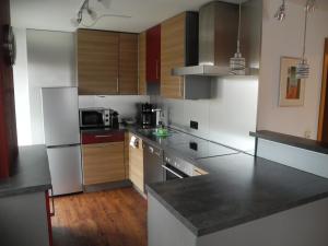 uma cozinha com utensílios de aço inoxidável e armários de madeira em Apartment Yvonne em Eimeldingen